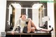 A woman sitting on top of a counter next to a mirror.