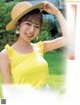 A woman in a yellow top and a straw hat.