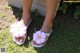 A pair of white sandals with pink flowers on them.