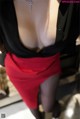 A woman in a black shirt and red skirt.